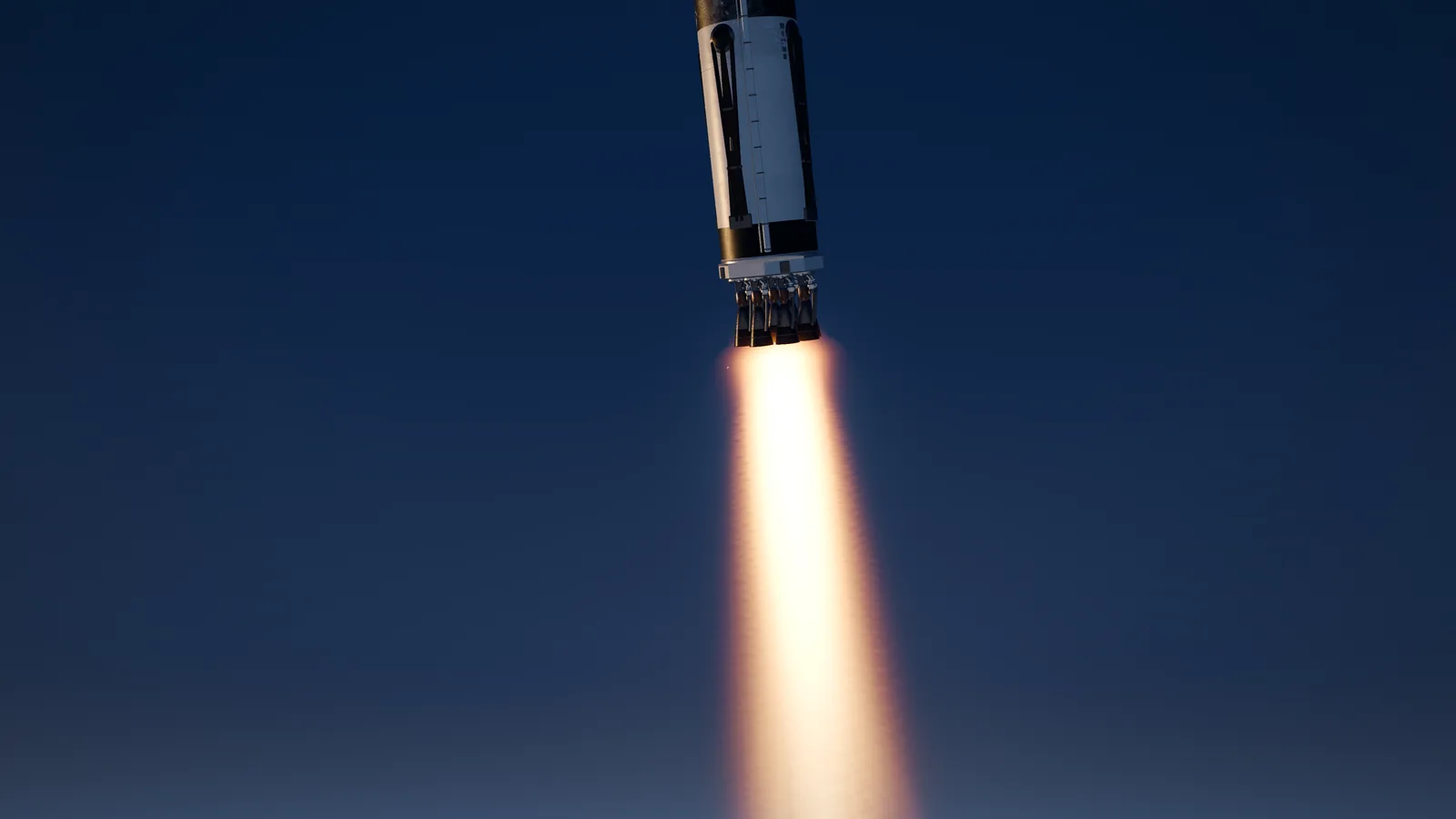 In-game capture from SpaceSim: Pale Blue Dot: a rocket stage firing its engines against a deep blue sky, the exhaust plume trailing below.